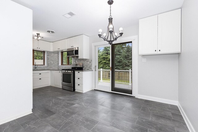 11S561 Saratoga Ave, Lemont, IL 60439 - kitchen with stainless steel appliances, a chandelier, baseboards, backsplash, and white cabinets