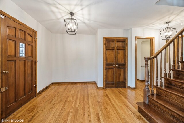 6483 Indianhead Trl, Indian Head Park, IL 60525 - foyer featuring a chandelier, stairway, light wood-type flooring, and baseboards