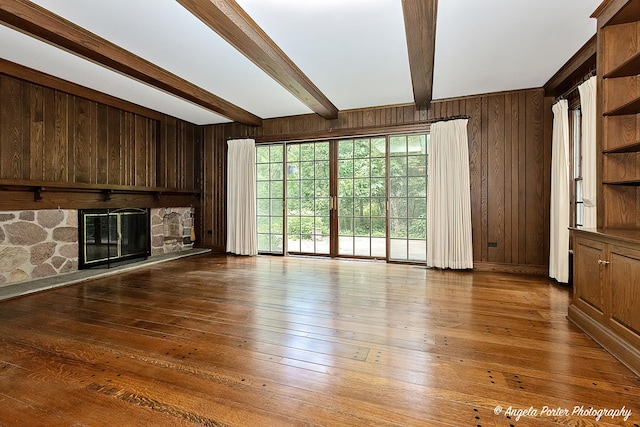 21293 N Andover Rd, Kildeer, IL 60047 - unfurnished living room featuring wood walls, beamed ceiling, a stone fireplace, and hardwood / wood-style floors