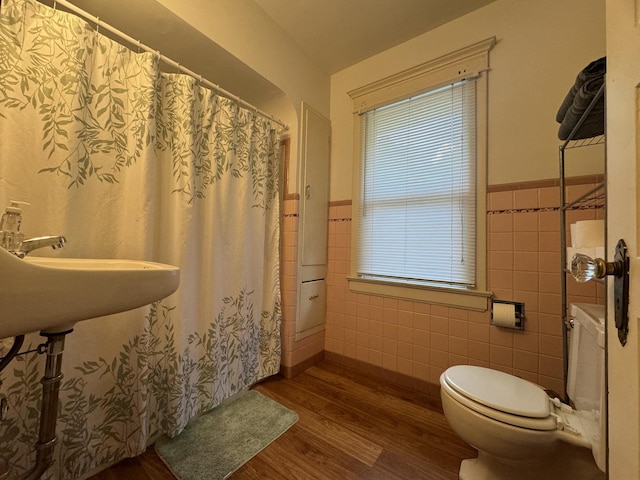 1309 S Main St, Bloomington, IL 61701 - full bath with tile walls, wood finished floors, toilet, wainscoting, and a shower with shower curtain