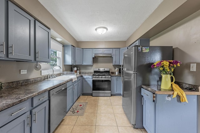 205 Glen St, West Chicago, IL 60185 - kitchen featuring appliances with stainless steel finishes, a sink, under cabinet range hood, a textured ceiling, and light tile patterned floors