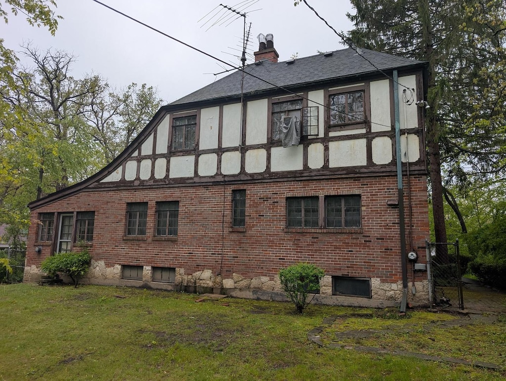 3107 Dato Ave, Highland Park, IL 60035 - view of side of home featuring a lawn, a chimney, brick siding, a shingled roof, and stucco siding