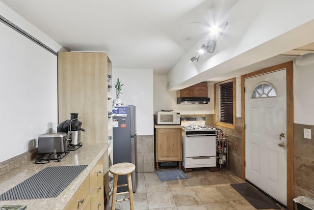 3524 N Lawndale Ave Unit 1G, Chicago, IL 60618 - kitchen featuring white appliances, under cabinet range hood, tile walls, light countertops, and wainscoting