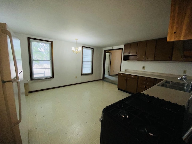 807 W Washington St, Pontiac, IL 61764 - kitchen featuring light floors, a sink, a chandelier, baseboards, and dark brown cabinets