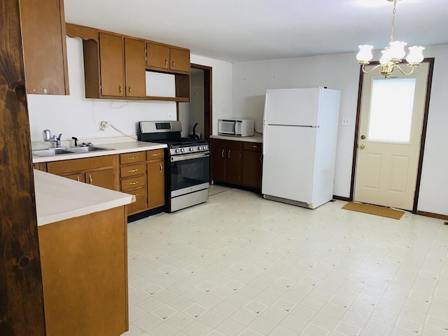 807 W Washington St, Pontiac, IL 61764 - kitchen featuring white appliances, light countertops, a sink, a chandelier, and brown cabinets