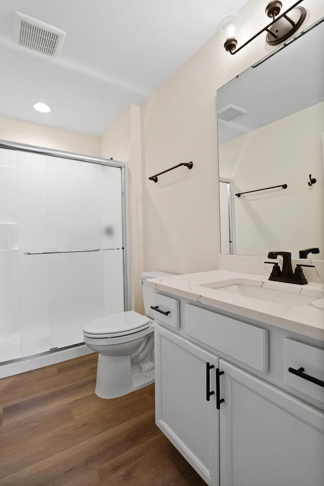 2034 W 75th Pl Unit 32, Merrillville, IN 46410 - bathroom with a shower stall, toilet, vanity, wood finished floors, and recessed lighting
