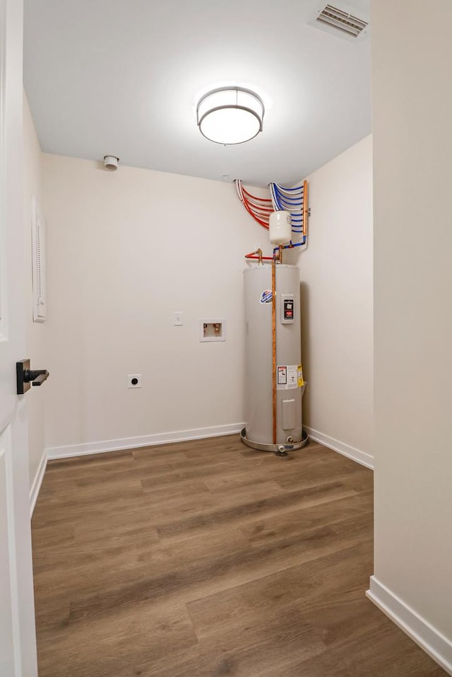2034 W 75th Pl Unit 32, Merrillville, IN 46410 - washroom featuring water heater, hookup for an electric dryer, hookup for a washing machine, baseboards, and wood finished floors
