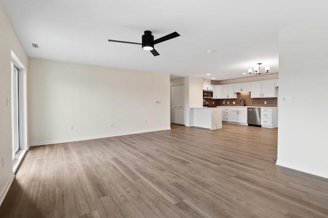 2034 W 75th Pl Unit 32, Merrillville, IN 46410 - unfurnished living room featuring light wood-type flooring, baseboards, a ceiling fan, a chandelier, and recessed lighting