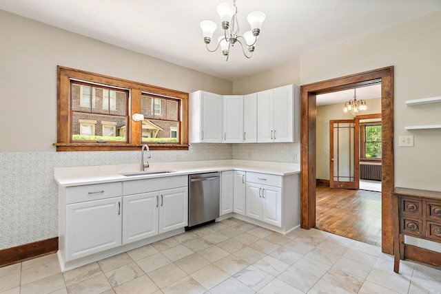 610 S 3rd St, Dekalb, IL 60115 - kitchen with stainless steel dishwasher, a chandelier, light countertops, white cabinets, and pendant lighting