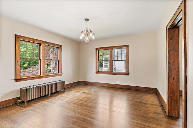 610 S 3rd St, Dekalb, IL 60115 - empty room featuring radiator, wood finished floors, and a chandelier