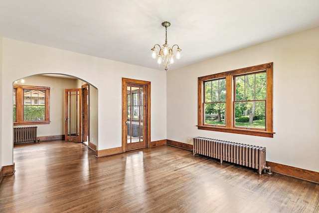 610 S 3rd St, Dekalb, IL 60115 - spare room with radiator heating unit, arched walkways, wood finished floors, and a chandelier