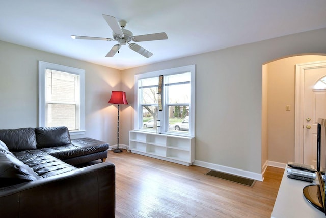1625 N 73rd Ct, Elmwood Park, IL 60707 - living room featuring arched walkways, light wood finished floors, a ceiling fan, and baseboards
