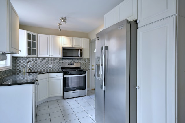 1625 N 73rd Ct, Elmwood Park, IL 60707 - kitchen featuring stainless steel appliances, a sink, dark countertops, tasteful backsplash, and white cabinets