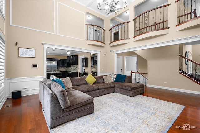 4748 Sassafras Ln, Naperville, IL 60564 - living room with a chandelier, dark wood-type flooring, a high ceiling, a wainscoted wall, and crown molding
