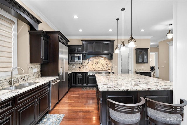 4748 Sassafras Ln, Naperville, IL 60564 - kitchen with appliances with stainless steel finishes, a sink, a kitchen island with sink, tasteful backsplash, and light stone countertops