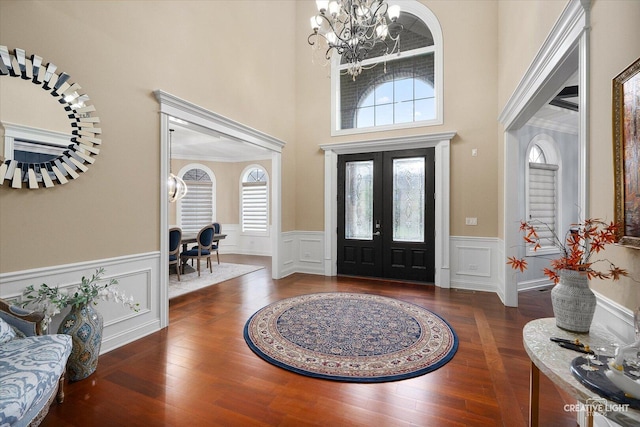 4748 Sassafras Ln, Naperville, IL 60564 - entrance foyer featuring a chandelier, a wainscoted wall, wood finished floors, a high ceiling, and a decorative wall