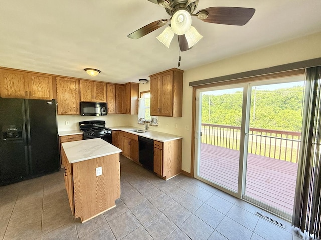 2123 Maxine Ln, Rockford, IL 61102 - kitchen with black appliances, a center island, brown cabinets, light countertops, and light tile patterned flooring