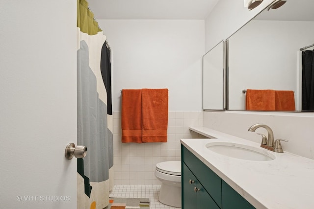 4250 N Marine Dr Unit 1406, Chicago, IL 60613 - bathroom featuring tile patterned floors, toilet, vanity, tile walls, and wainscoting