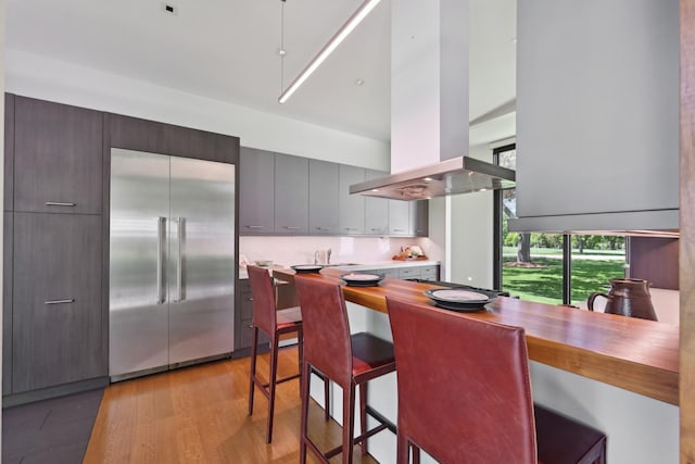 4N575 Old Quarry Rd, Saint Charles, IL 60174 - kitchen with stainless steel built in refrigerator, light wood-style floors, island exhaust hood, a high ceiling, and a kitchen breakfast bar