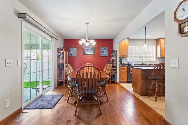 3807 Sandstone Dr, Champaign, IL 61822 - dining area featuring a chandelier, light wood-type flooring, and healthy amount of natural light