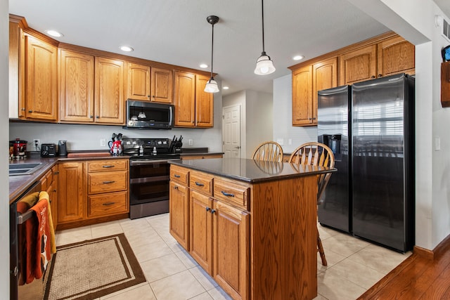 3807 Sandstone Dr, Champaign, IL 61822 - kitchen with stainless steel appliances, dark countertops, a center island, recessed lighting, and light tile patterned floors