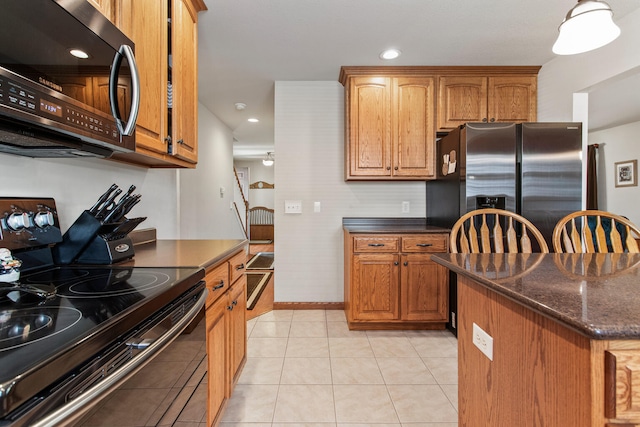 3807 Sandstone Dr, Champaign, IL 61822 - kitchen with stainless steel appliances, dark stone counters, baseboards, brown cabinetry, and recessed lighting
