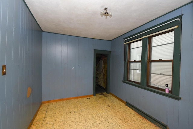 937 N County St, Waukegan, IL 60085 - spare room featuring light flooring, wood walls, and baseboards