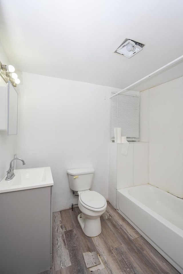 937 N County St, Waukegan, IL 60085 - full bath with toilet, wood finished floors, vanity, and washtub / shower combination
