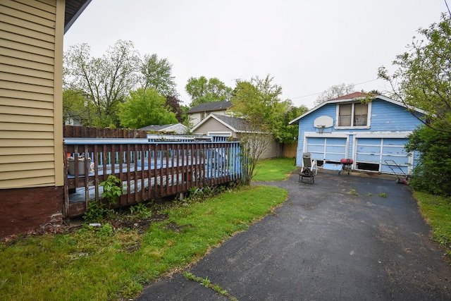 937 N County St, Waukegan, IL 60085 - view of yard featuring a garage, a wooden deck, and an outbuilding