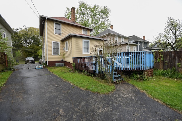 937 N County St, Waukegan, IL 60085 - rear view of property featuring a deck, central air condition unit, and a gate