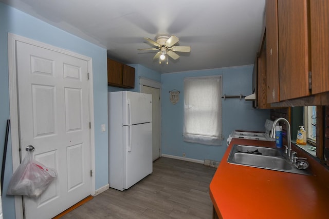 937 N County St, Waukegan, IL 60085 - kitchen featuring freestanding refrigerator, a sink, ceiling fan, stove, and dark wood-style flooring