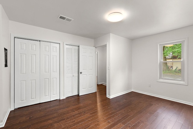 21402 S 79th Ave, Frankfort, IL 60423 - unfurnished bedroom with dark wood finished floors, baseboards, and two closets