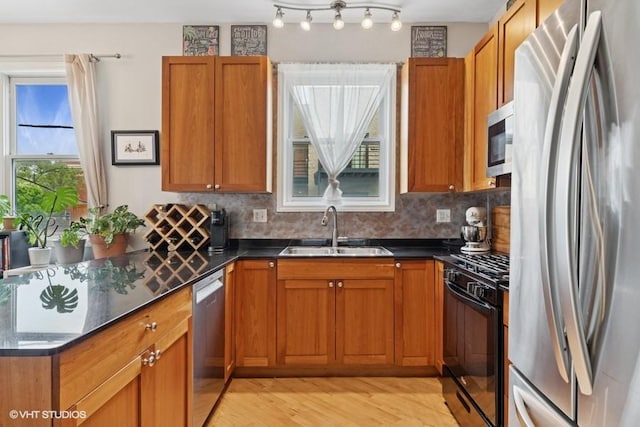 2215 W Augusta Blvd Unit 2E, Chicago, IL 60622 - kitchen featuring appliances with stainless steel finishes, a sink, light wood-style flooring, and dark countertops