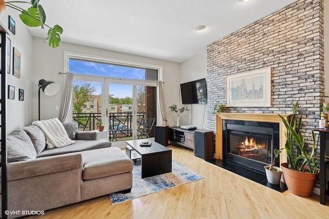 2215 W Augusta Blvd Unit 2E, Chicago, IL 60622 - living room featuring a brick fireplace, wood finished floors, and brick wall