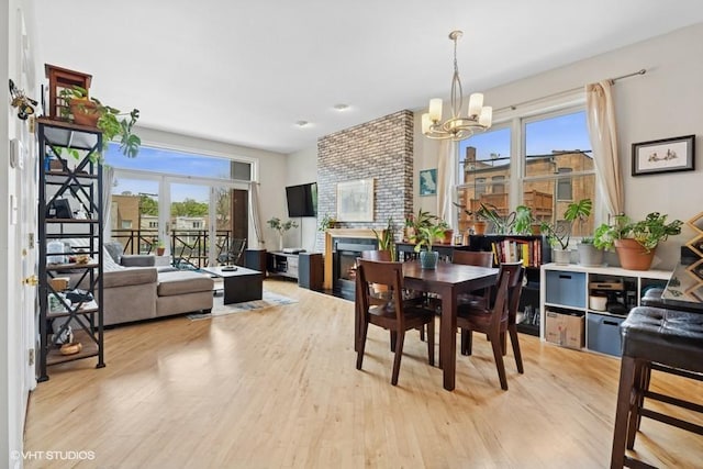 2215 W Augusta Blvd Unit 2E, Chicago, IL 60622 - dining area featuring a chandelier, light wood-type flooring, and a fireplace