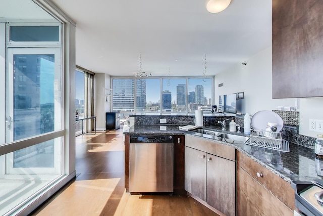757 N Orleans St Unit 909, Chicago, IL 60654 - kitchen featuring stainless steel dishwasher, a sink, dark wood-style floors, and dark stone counters
