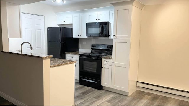 633 Virginia Rd Unit 116, Crystal Lake, IL 60014 - kitchen with black appliances, baseboard heating, dark stone counters, light wood-style flooring, and white cabinetry