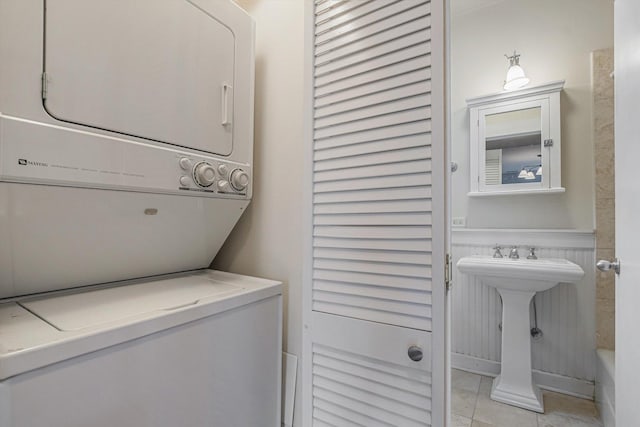 626 Judson Ave Unit 3, Evanston, IL 60202 - laundry area with stacked washer and clothes dryer, light tile patterned floors, and wainscoting