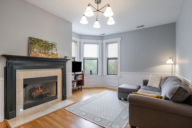 626 Judson Ave Unit 3, Evanston, IL 60202 - living area with a chandelier, light wood finished floors, a fireplace, and a wainscoted wall