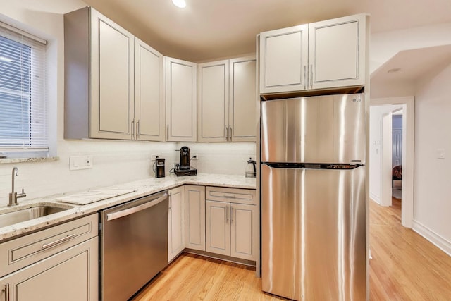 5319 W Cullom Ave, Chicago, IL 60641 - kitchen with stainless steel appliances, a sink, light wood-style flooring, light stone counters, and tasteful backsplash