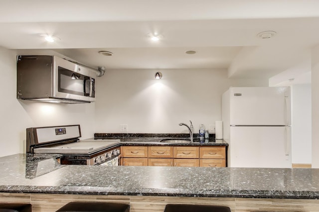 5319 W Cullom Ave, Chicago, IL 60641 - kitchen featuring stainless steel appliances, a sink, light brown cabinets, and dark stone countertops