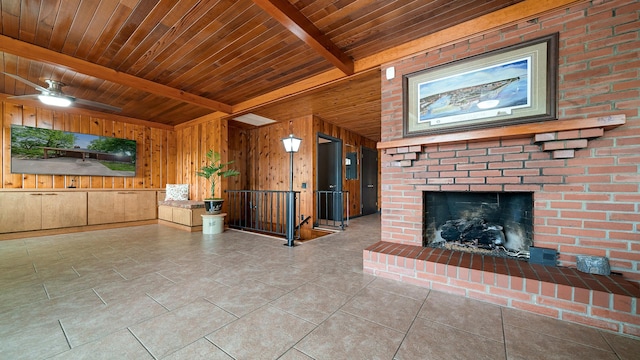 605 N 4th St, Oregon, IL 61061 - unfurnished living room with wood walls, a fireplace, wood ceiling with exposed beams, tile patterned floors, and ceiling fan