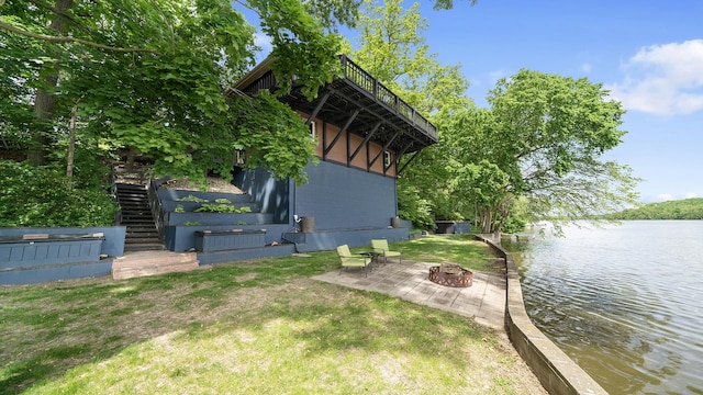 605 N 4th St, Oregon, IL 61061 - view of side of home featuring stairs, a water view, an outdoor fire pit, a yard, and a patio area