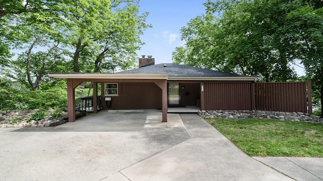 605 N 4th St, Oregon, IL 61061 - view of front of home featuring a chimney, an attached carport, roof with shingles, concrete driveway, and a front yard