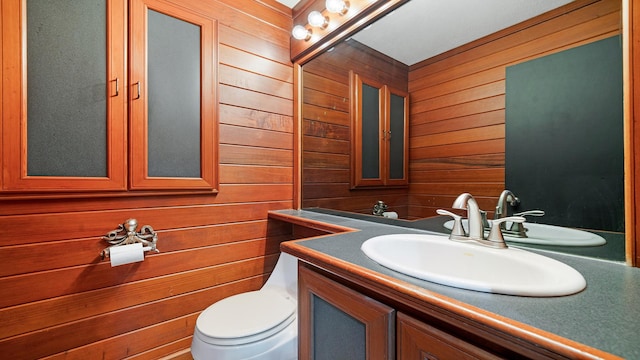 605 N 4th St, Oregon, IL 61061 - bathroom featuring wood walls, vanity, and toilet
