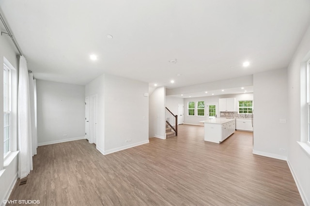 790 Weller Dr, Des Plaines, IL 60016 - unfurnished living room with recessed lighting, light wood-type flooring, stairs, and baseboards