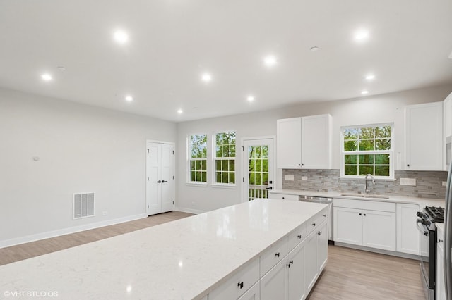790 Weller Dr, Des Plaines, IL 60016 - kitchen with a sink, appliances with stainless steel finishes, light stone countertops, backsplash, and light wood-style floors