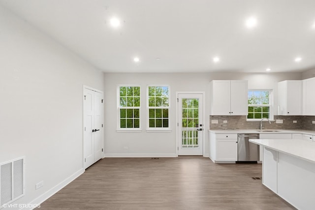 790 Weller Dr, Des Plaines, IL 60016 - kitchen with stainless steel dishwasher, a sink, light countertops, tasteful backsplash, and white cabinets
