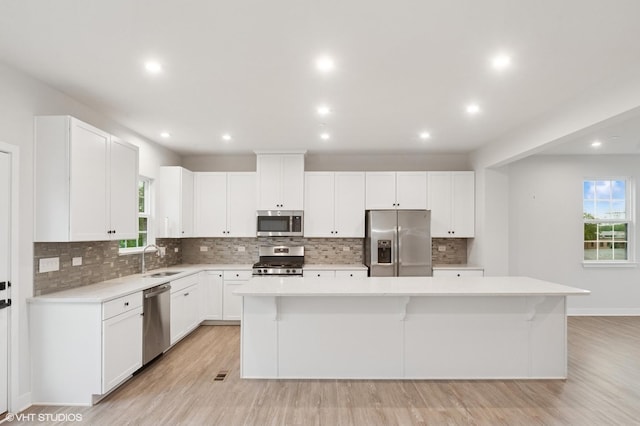 790 Weller Dr, Des Plaines, IL 60016 - kitchen featuring appliances with stainless steel finishes, a sink, a kitchen island, light countertops, and recessed lighting