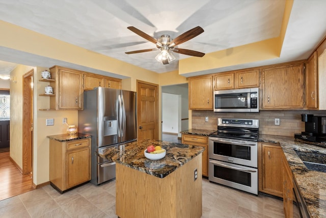 307 Shelden Dr, Winnebago, IL 61088 - kitchen featuring stainless steel appliances, a ceiling fan, dark stone counters, and decorative backsplash